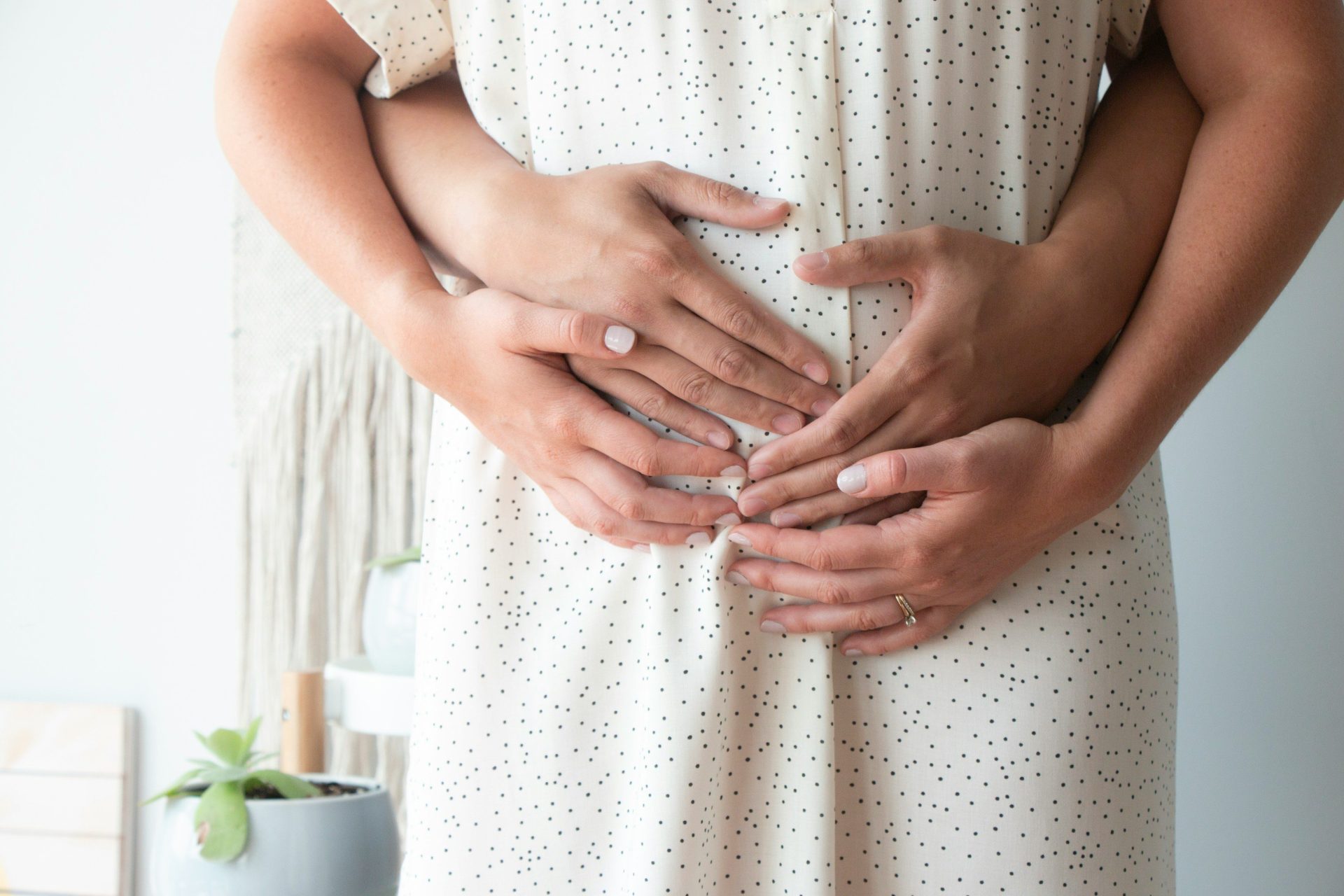 Person berührt den Bauch einer anderen Person